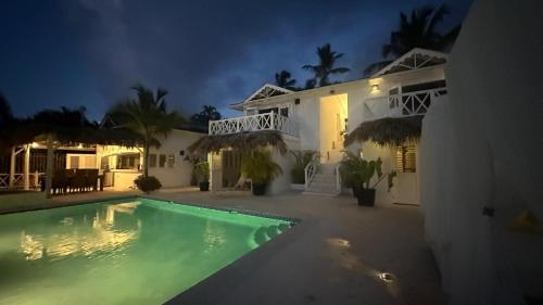 a house with a swimming pool at night at Villa blanca chambre d'hôtes vue sur mer in Las Terrenas