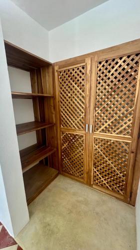 a closet with wooden doors and shelves at Villa blanca chambre d'hôtes vue sur mer in Las Terrenas