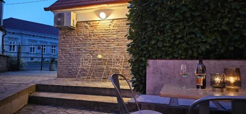 a table with wine glasses on it next to a building at Apartment Piaf in Donja Dubrava