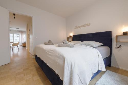 a bedroom with a large bed with a teddy bear on it at Ferienwohnung Konrad in Friedrichshafen