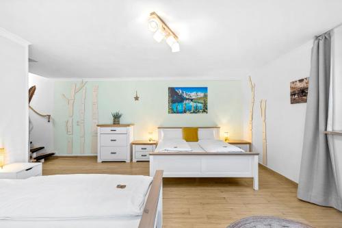 a white bedroom with two beds in it at CASARiNA - Alpentraum am Barmsee - FeWo Lugge in Krün
