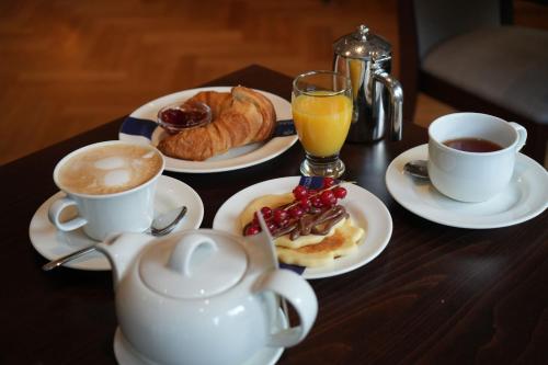 a table with two cups of coffee and a plate of food at Ringhotel Appelbaum Gütersloh in Gütersloh