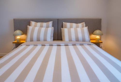 - une chambre avec un grand lit et des oreillers rayés dans l'établissement #301- Heart of Vieil Antibes - Place Nationale-High-End Newly Renovated & Furnished Appartment, à Antibes