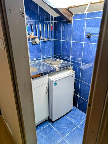 a blue tiled bathroom with a sink and a washing machine at Sunset Dreams Utjeha in Utjeha