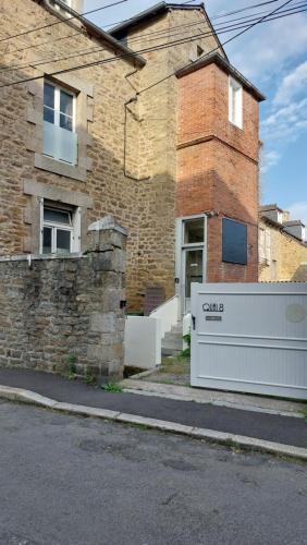 un bâtiment en brique avec une porte devant lui dans l'établissement Quai 8, à Dinan