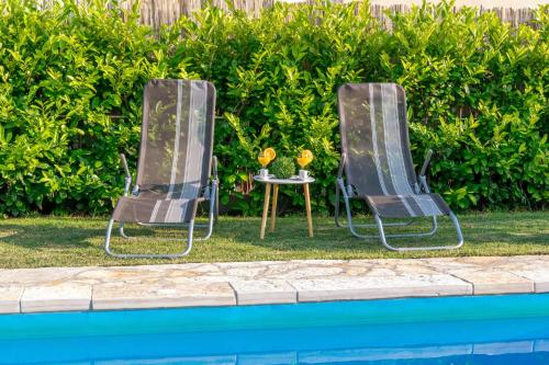 two chairs and a table next to a swimming pool at Ferienhaus In Posedarje Mit Großem Garten in Posedarje