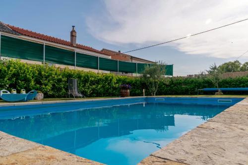 a swimming pool in front of a house at Ferienhaus In Posedarje Mit Großem Garten in Posedarje