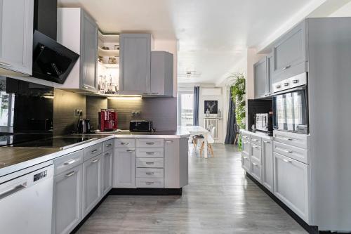 une cuisine avec des placards blancs et un grand comptoir blanc dans l'établissement 5p 100 m2 Garage 2 BalconiesStrasbourg center, à Strasbourg