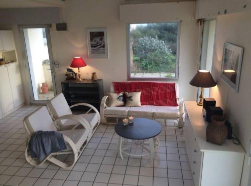 un salon avec un canapé, des chaises et une table dans l'établissement Maison vue mer 8 personnes - Finistère Sud, à Moëlan-sur-Mer