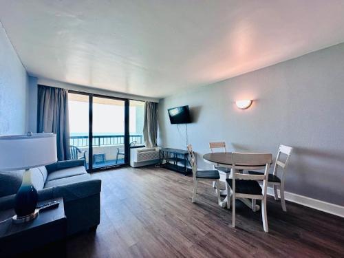a living room with a couch and a table at Updated Oceanfront Pools & More S129 in Myrtle Beach