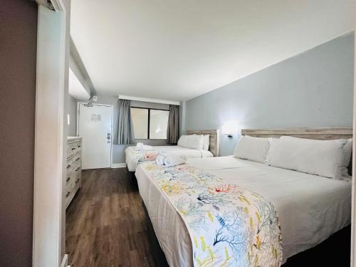 a bedroom with two beds with white sheets at Updated Oceanfront Pools & More S129 in Myrtle Beach