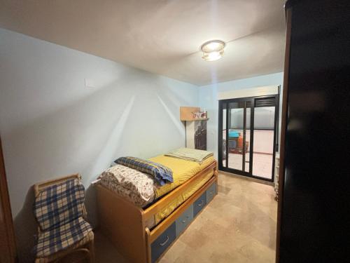 a bedroom with a bed and a chair in it at Piso cercano al puerto in Denia