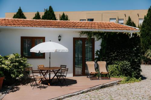 a patio with a table and chairs and an umbrella at Casa dos meus avós -Villas - Gaia & Porto in Vila Nova de Gaia