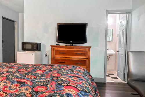 a bedroom with a bed and a television on a dresser at OYO Hotel Jonesboro Near Atlanta Airport in Jonesboro