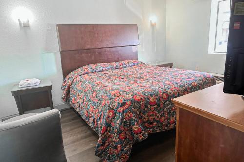 a bedroom with a bed with a colorful comforter at OYO Hotel Jonesboro Near Atlanta Airport in Jonesboro