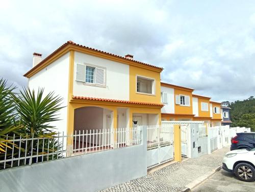 a house with a white fence at Casa das Rosas - Moradia com jardim e churrasco, Charneca da Cotovia in Sesimbra