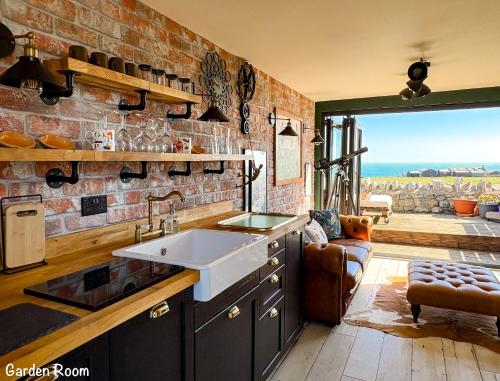 a kitchen with a sink and a brick wall at BillWatch Cottage in Southwell