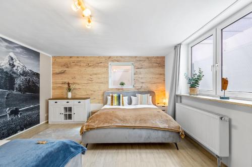 a bedroom with a bed and a wall of windows at CASARINA - Alpentraum am Barmsee mit Garten in Krün