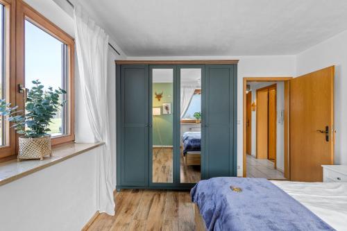 a bedroom with a blue door and a bed at CASARINA - Alpentraum am Barmsee mit Garten in Krün