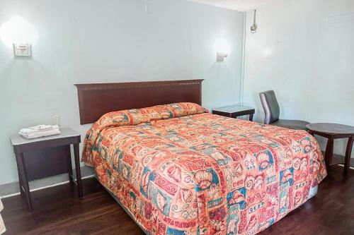 a bedroom with a bed with a colorful comforter at OYO Hotel Jonesboro Near Atlanta Airport in Jonesboro