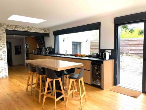 une cuisine avec une table et des chaises en bois dans l'établissement Demeure Familiale Haut de Gamme 230m2 en Centre-Ville de Nantes Tramway à 2 min, à Nantes