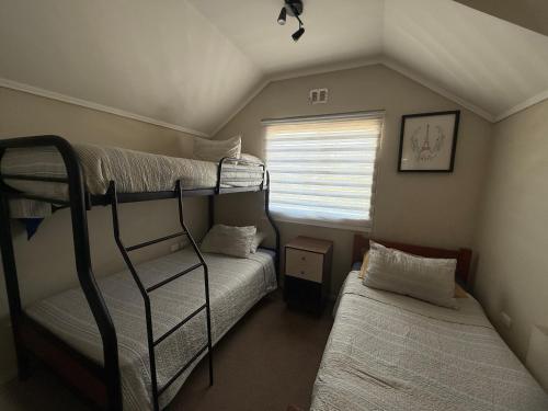 a room with two bunk beds and a window at Apart Hotel Chillan - Home Cozy - Empresas - Factura - Aire acondicionado - Parking - wifi - servicio opcional pensión completa in Chillán