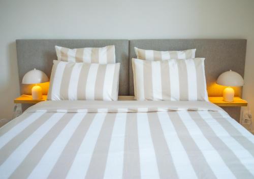 - un lit avec des oreillers blancs et 2 lampes sur les tables dans l'établissement #201-Heart of Vieil Antibes - Place Nationale-High-End Newly Renovated & Furnished Appartment, à Antibes