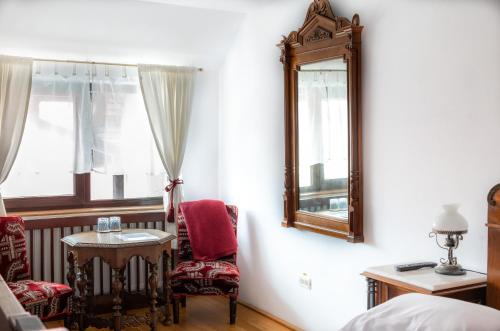 a bedroom with a mirror and a table and a chair at Casa Maria in Bran