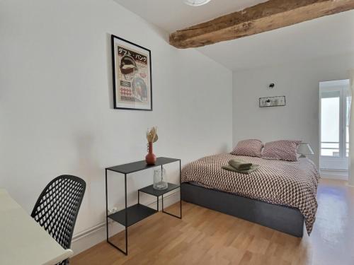 une chambre avec un lit, une table et une chaise dans l'établissement Maison chaleureuse de 5 chambres au cœur de la ville, à Ambérieu-en-Bugey