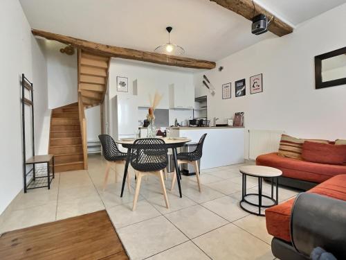un salon avec une table et des chaises et une cuisine dans l'établissement Maison chaleureuse de 5 chambres au cœur de la ville, à Ambérieu-en-Bugey
