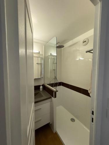 une salle de bain blanche avec un lavabo et un miroir dans l'établissement T2 Saint-Raphaël, Cap Esterel village, vue mer, rez de jardin, à Saint-Raphaël