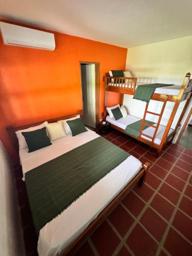 two bunk beds in a room with orange walls at Splendide villa à morro branco vue sur mer in Beberibe