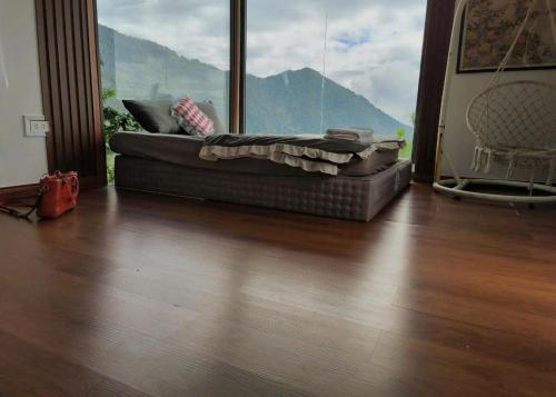 a couch in a living room with a large window at BUNGALOW 2 -phòng săn mây vạn người mê in Tam Ðảo