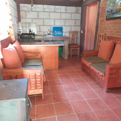 a living room with a couch and a table at Acogedora cabaña cerca de La Marquesa in San Pedro Atlapulco