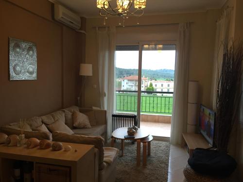 a living room with a couch and a large window at POSSIDI - Ithaki Holiday Apartments in Kalandra