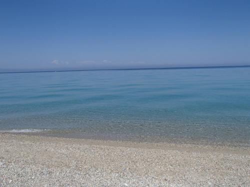 a beach with clear blue water and a rocky shore at POSSIDI - Ithaki Holiday Apartments in Kalandra