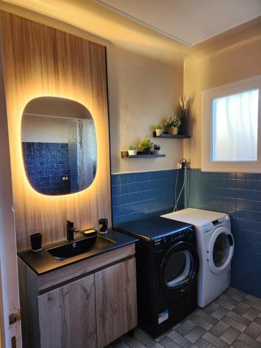 une salle de bain avec une machine à laver et un lavabo dans l'établissement Hossegor, Maison Familiale Intergénérationnelle , Quartier Calme et Résidentiel, à Hossegor
