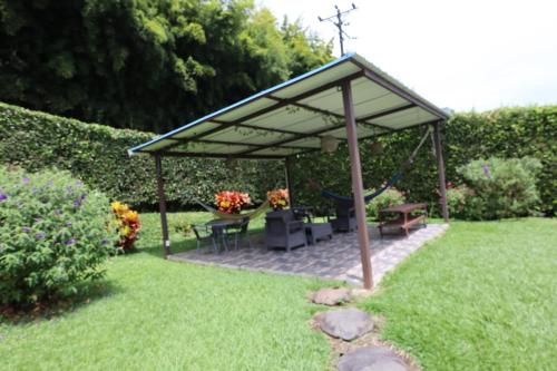 a pavilion with tables and chairs in a garden at Hotel Syvanna Wellness and Spa in Pereira