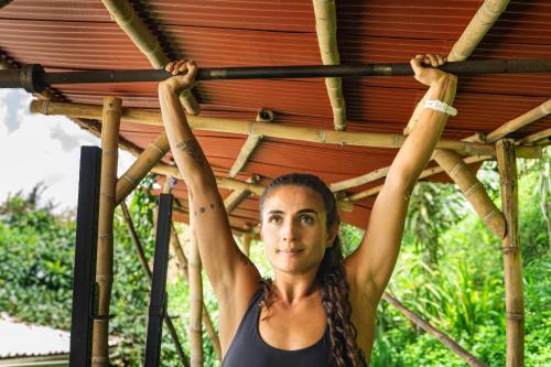 a woman is holding up a wooden structure at Casa Encuentro Ecolodge, Outdoor Gym and Yoga in Guatapé