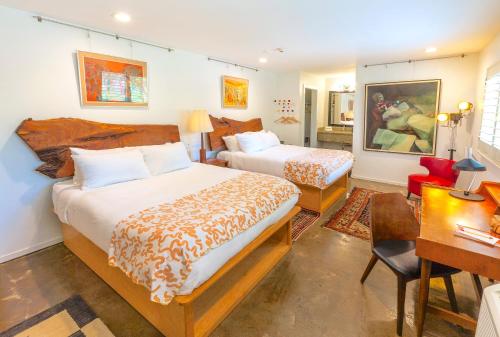 a hotel room with two beds and a desk and a desk at The Astro in Santa Rosa