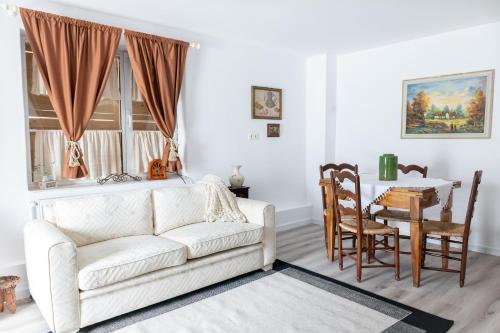a living room with a white couch and a table at Casa Maria in Bran