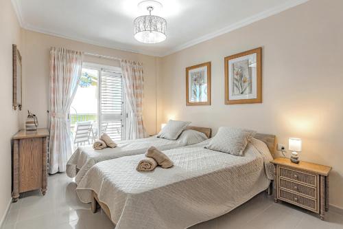 Un dormitorio con dos camas y una ventana en La Perla Beach Vibes, en Puerto de Santiago