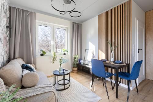 una sala de estar con un sofá, una mesa y sillas en Enduro Spot - Apartament pod Kozią Górą, en Bielsko-Biala