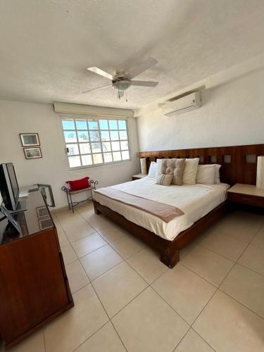 une chambre avec un lit et un ventilateur de plafond dans l'établissement Luxurios house, pool and beach YOUR OASIS, à Acapulco