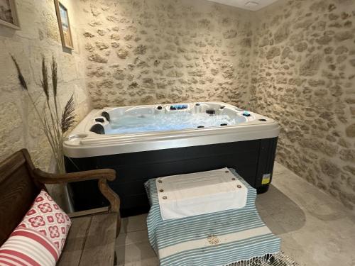 een badkamer met een jacuzzi in een kamer bij Maison JEROBOAM in Saint-Estèphe