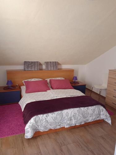 a bedroom with a large bed with pink pillows at Apartment Inter Vivos in Smokvica