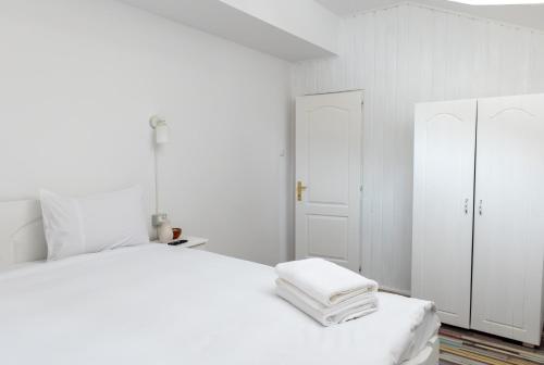 a white bedroom with a white bed and white cabinets at Casa Maria in Bran