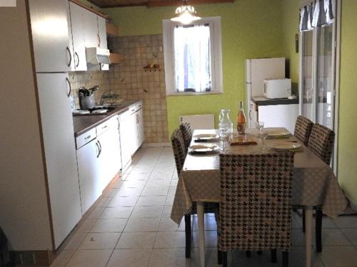 Il comprend une cuisine équipée d'une table avec des chaises et d'un réfrigérateur blanc. dans l'établissement La Cévane, à Chorges