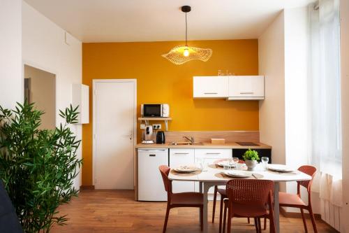 kuchnia ze stołem i krzesłami w pokoju w obiekcie Cocon Marguerite - Appartement cosy - Idéal pro et cyclistes w mieście Mayenne