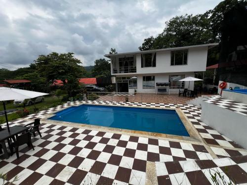 a house with a swimming pool and a checkered floor at Finca de descanso Brisas de Calandaima in Viotá